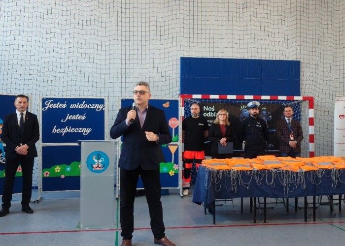 Zdjęcie 3. Na zdjęciu od lewej: Pan Sylwester Winek – Wójt Gminy Kołbiel, (z mikrofonem) przemawiający do uczestników spotkania Pan Artur Rola – Dyrektor Delegatury Urzędu Marszałkowskiego Województwa Mazowieckiego w Wołominie, Pan Piotr Żak - ratownik medyczny z SPZOZ MEDITRANS w Warszawie, Pani Małgorzata Szerszeń – Dyrektor SP w Kołbieli, sierżant Piotr Świątek – Policjant z Komendy Powiatowej Policji w Otwocku oraz Pan Sławomir Bakalarski – Egzaminator z Wojewódzkiego Ośrodka Ruchu Drogowego w Warszawie. (zdjęcie źródło: WORD w Warszawie).